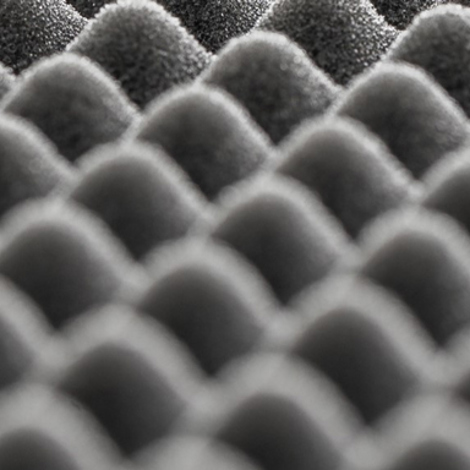 Close-up of a textured, grey, egg crate foam pattern, used for soundproofing.