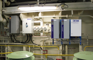 DESMI OptiSave energy-saving system with gauges and control panels for fluid handling.