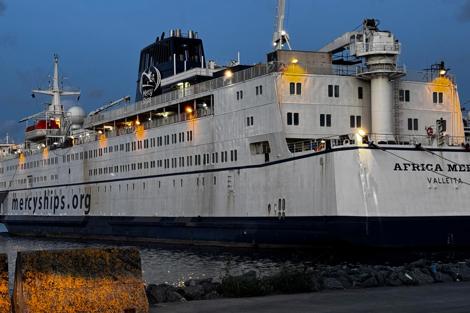 Ship "Africa Mercy" docked at port, displaying "mercyships.org" on its side.