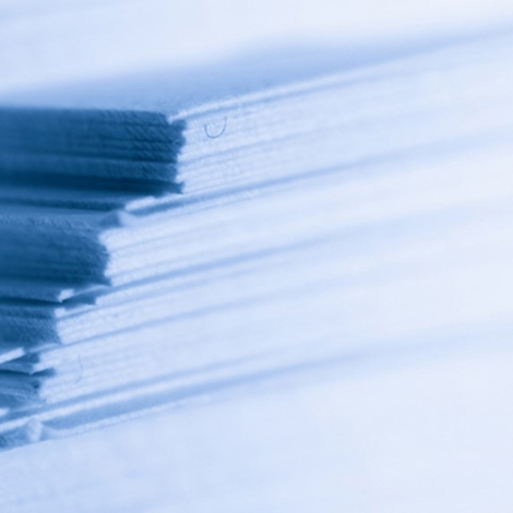 Close-up of stacked paper sheets with a soft blue tint.